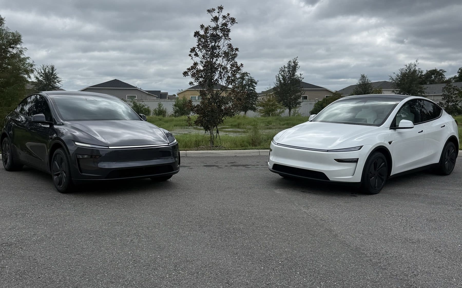 A gray and a white Tesla Model Y parked side by side