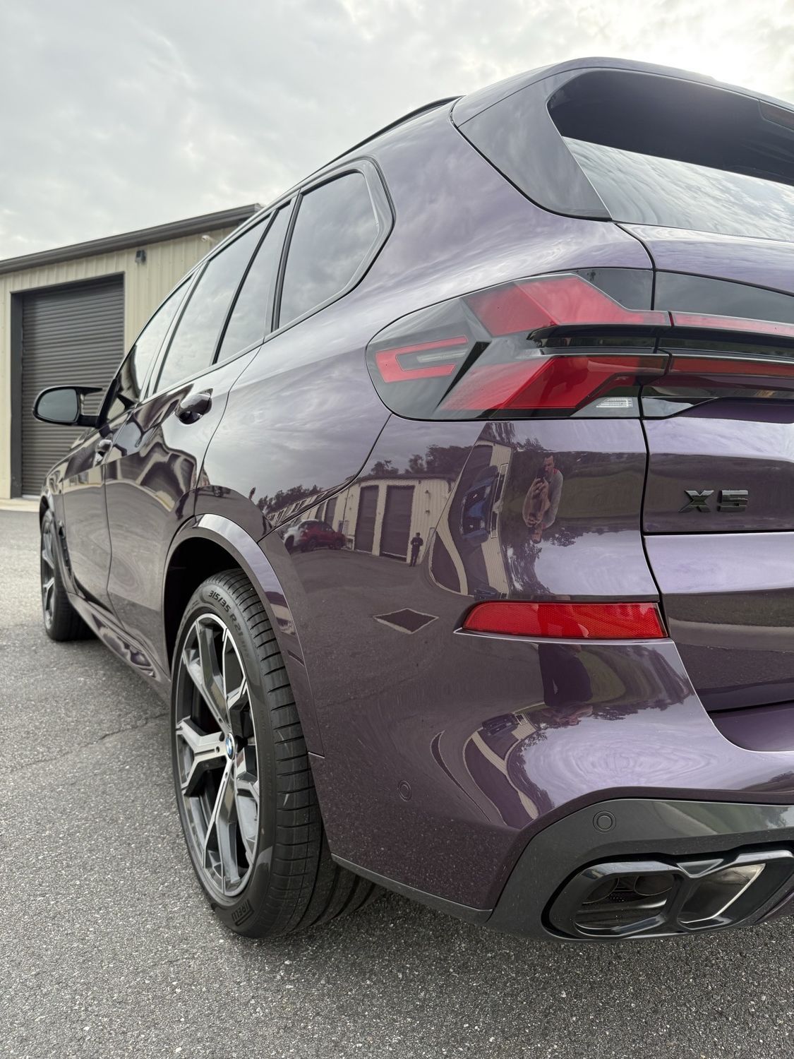 Rear quarter panel of a purple 2026 BMW X5 with full body PPF, ceramic coating, and ceramic window tint
